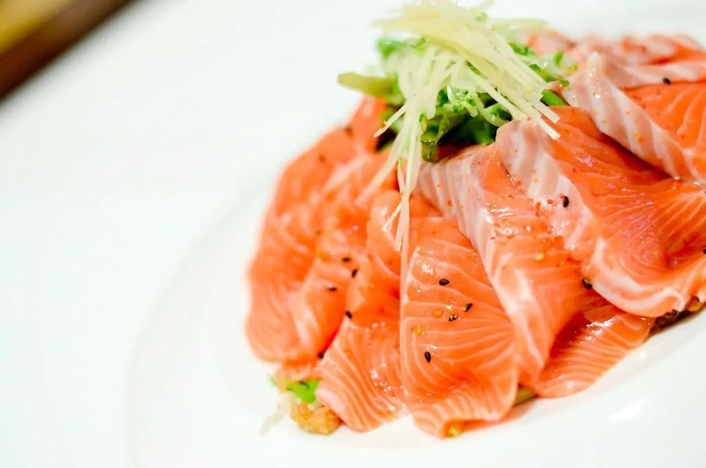 Fresh salmon sashimi salad on a white plate