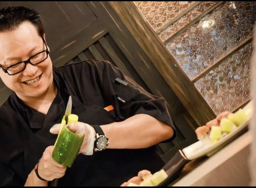 Chef Pete preparing Japanese cuisine with a smile at the sushi counter